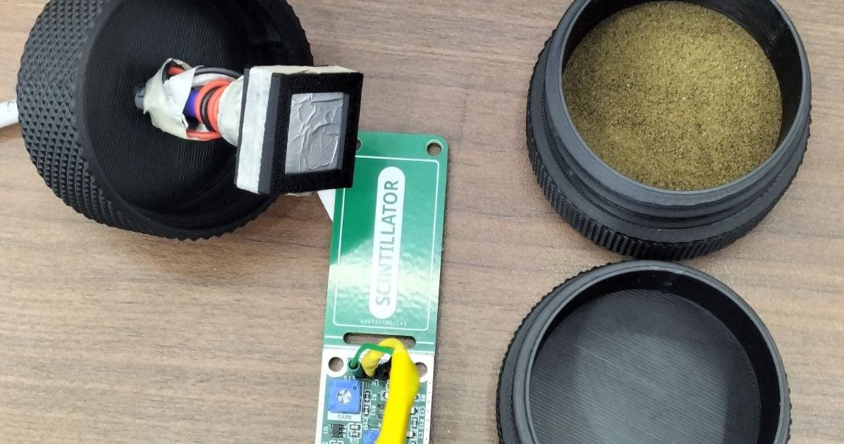 The complete setup. On the left, the detector head with its foil window is mounted in the enclosure lid. In the centre is the Mini SiD SiPM front-end board, with adjustable gain, threshold and SiPM bias. On the right, monazite sand sits in the base of th