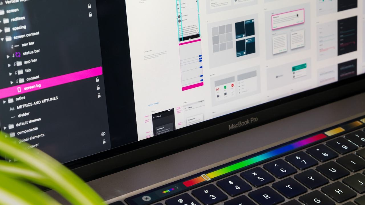 A laptop displaying a software user-interface design workspace with app screens